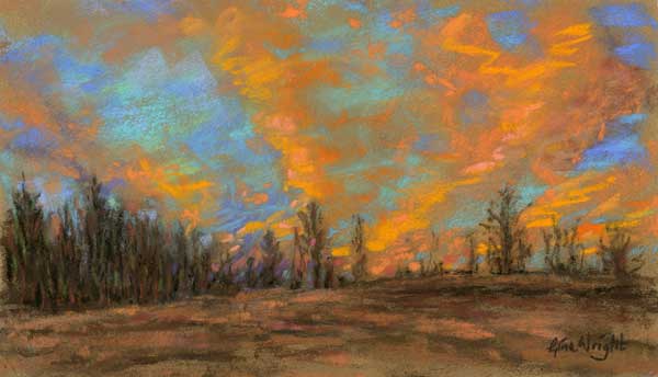 Clouds lit orange over hill top trees