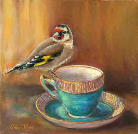 Still life of a goldfinch perched on a gold and turquoise tea cup